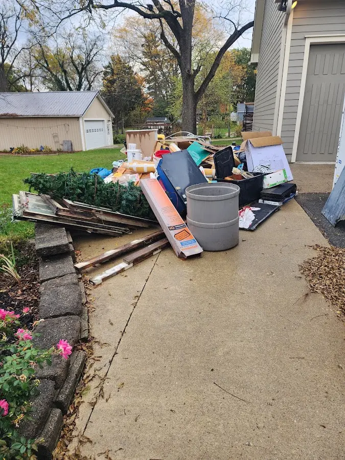 Dumpster being loaded with debris for 12 Yard Dumpster Rental in Hermantown